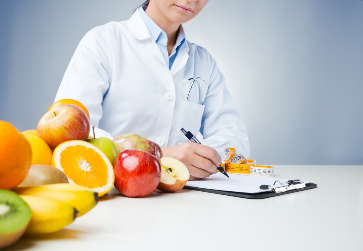 Doctor writing medical records with fresh fruit