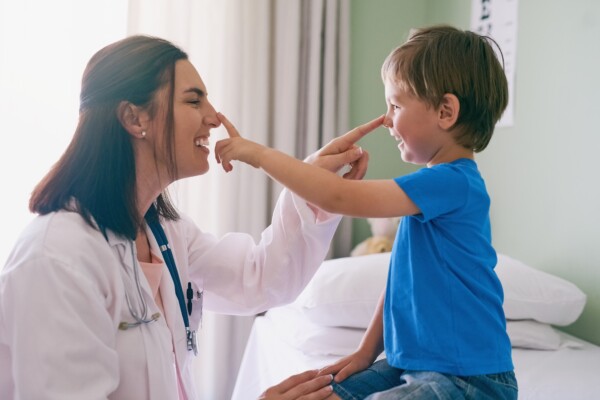 Doctor playing and laughing with boy patient.