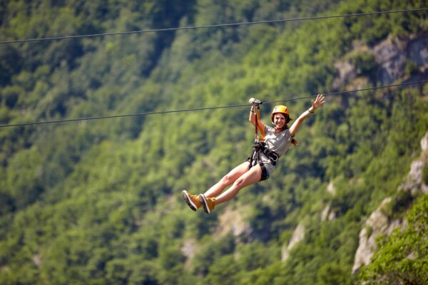 A girl ziplining over a rainforest