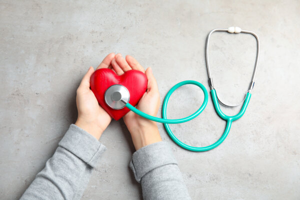 Woman holding red heart and stethoscope